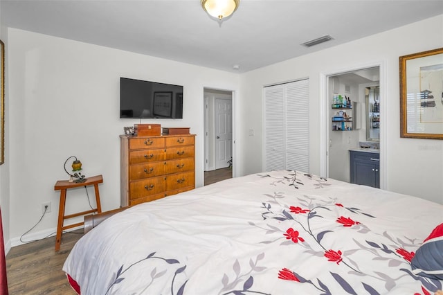 bedroom featuring ensuite bath, a closet, and dark hardwood / wood-style floors