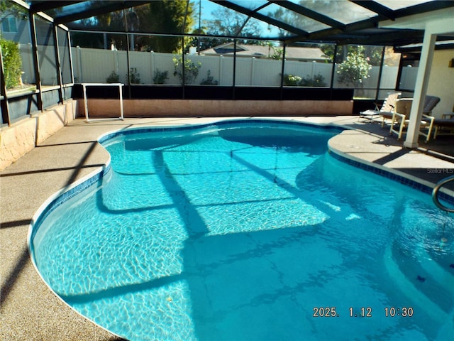 view of pool featuring glass enclosure and a patio