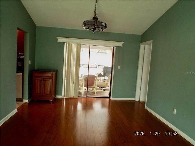 empty room with vaulted ceiling, hardwood / wood-style floors, and a notable chandelier