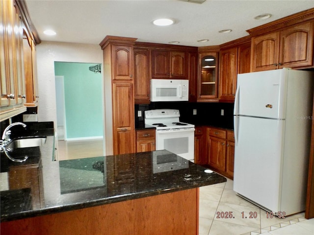 kitchen featuring sink, white appliances, dark stone counters, and light tile patterned flooring