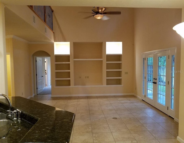 interior space featuring built in shelves, ceiling fan, sink, french doors, and light tile patterned flooring