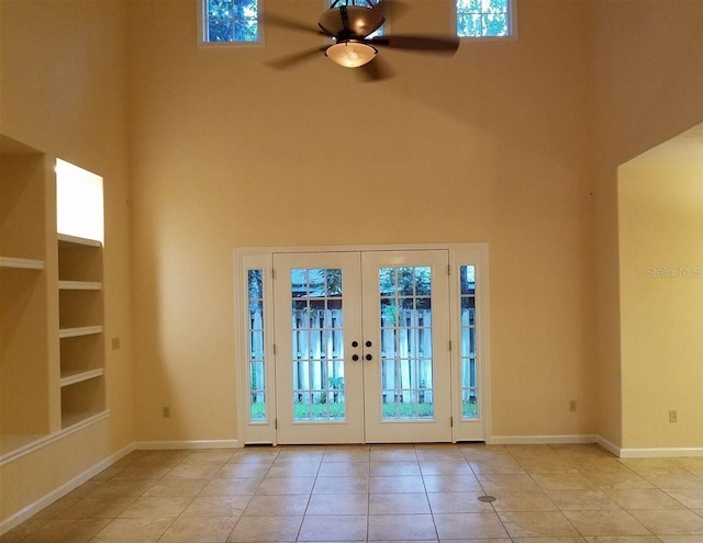 entrance foyer featuring a towering ceiling, ceiling fan, french doors, and light tile patterned flooring