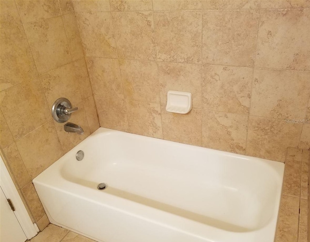 bathroom featuring tile patterned flooring and a washtub