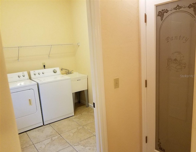 laundry room featuring washing machine and dryer and light tile patterned flooring