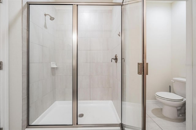 bathroom featuring walk in shower, tile patterned floors, and toilet