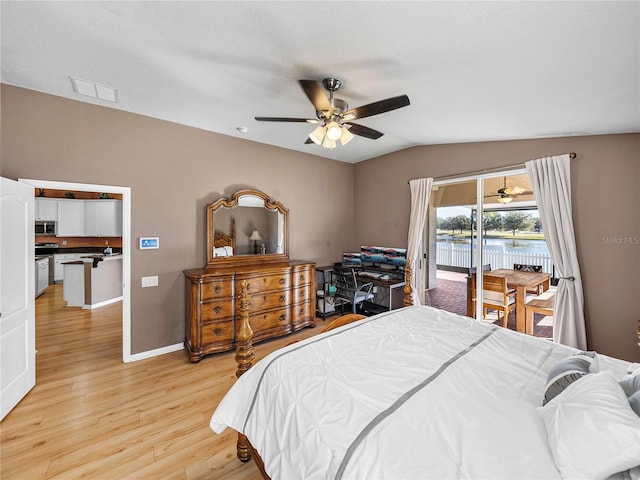 bedroom with vaulted ceiling, light wood-type flooring, ceiling fan, access to exterior, and a water view