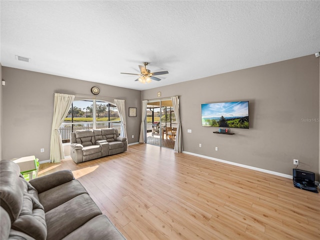 unfurnished living room with light hardwood / wood-style floors, ceiling fan, and a textured ceiling