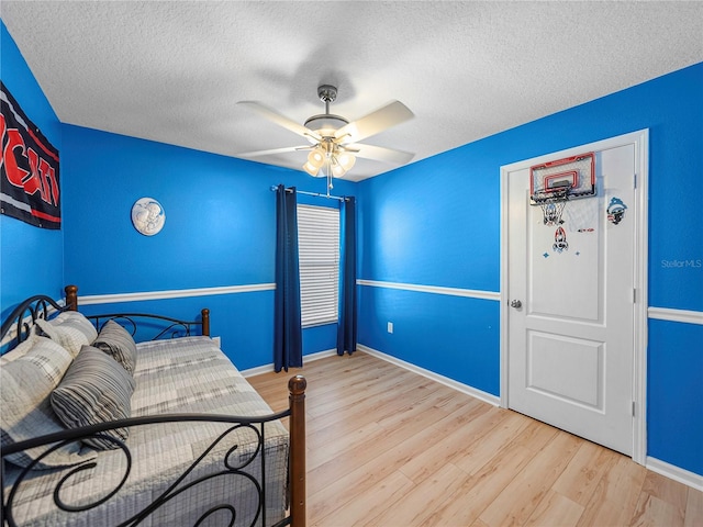 bedroom featuring a textured ceiling, ceiling fan, and light hardwood / wood-style floors