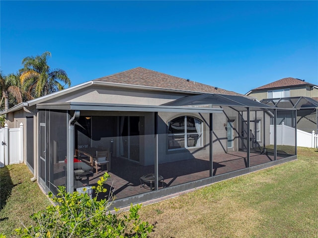 rear view of house featuring a lanai and a yard