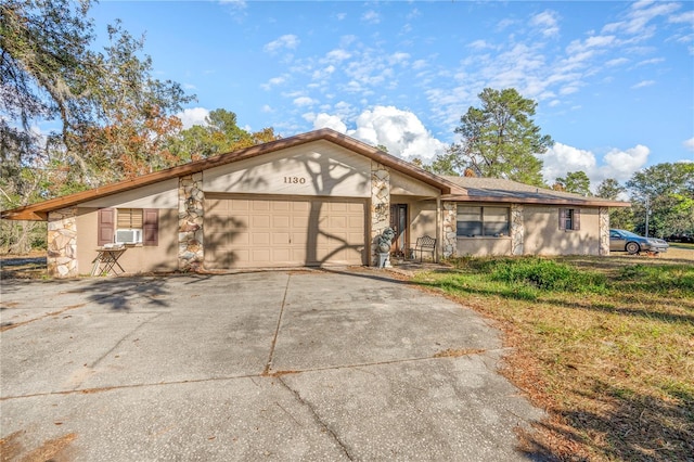 ranch-style home with a garage and cooling unit