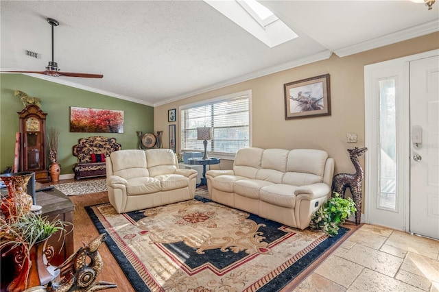 living room featuring a textured ceiling, ceiling fan, lofted ceiling with skylight, and ornamental molding