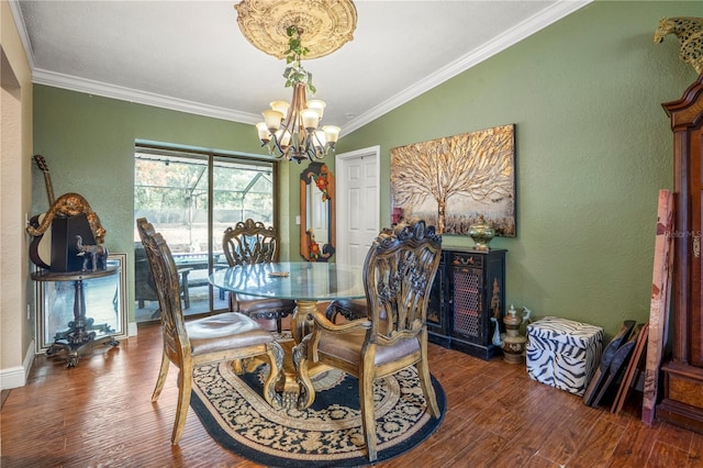 dining space featuring dark hardwood / wood-style flooring, an inviting chandelier, vaulted ceiling, and ornamental molding