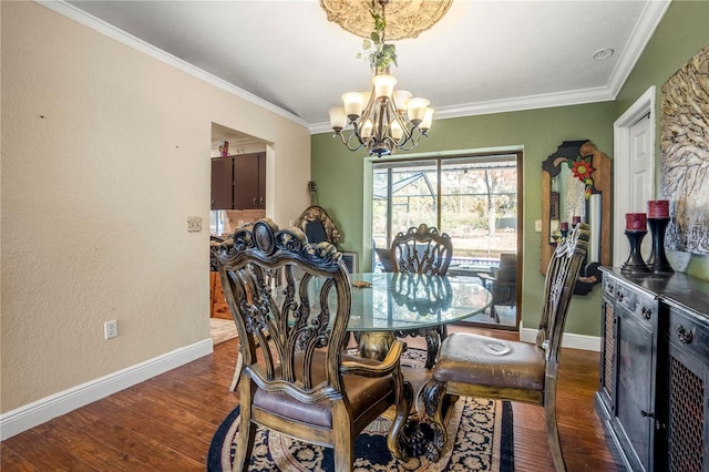 dining space featuring dark hardwood / wood-style floors, crown molding, and a chandelier