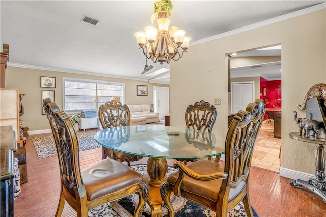 dining room with hardwood / wood-style floors, a notable chandelier, and crown molding