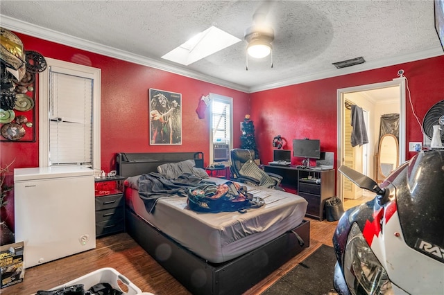 bedroom with ceiling fan, crown molding, refrigerator, and a textured ceiling