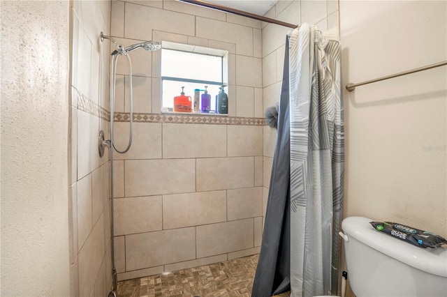 bathroom with curtained shower, toilet, and parquet flooring