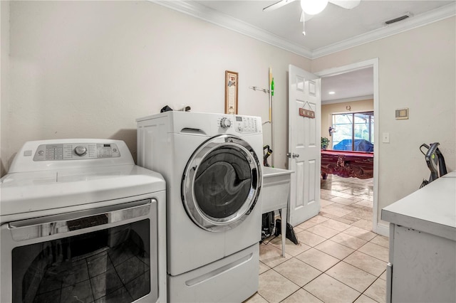 laundry area with light tile patterned floors, ceiling fan, ornamental molding, and washing machine and clothes dryer