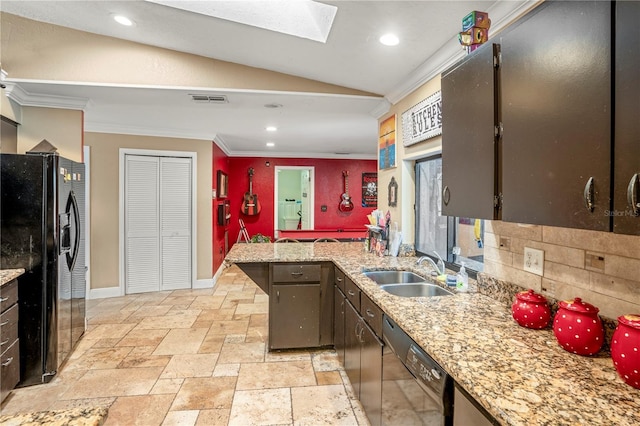 kitchen with black appliances, sink, vaulted ceiling with skylight, ornamental molding, and light stone counters