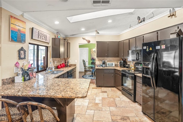 kitchen featuring a kitchen breakfast bar, kitchen peninsula, black appliances, and ornamental molding