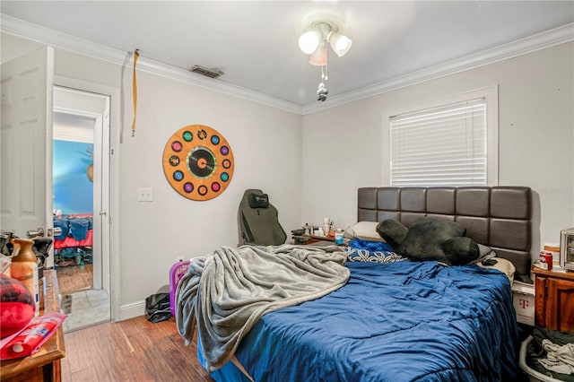 bedroom featuring hardwood / wood-style floors and ornamental molding