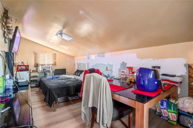 bedroom featuring light hardwood / wood-style flooring and lofted ceiling