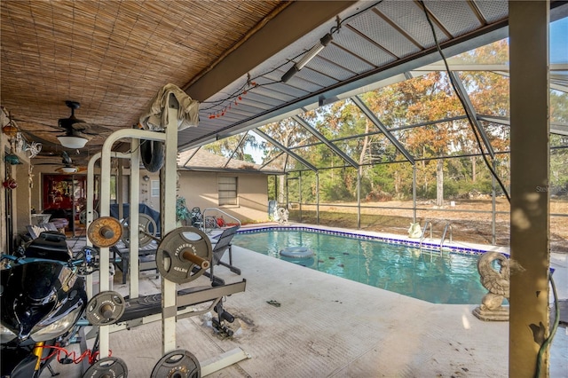 view of swimming pool with a lanai, ceiling fan, and a patio area