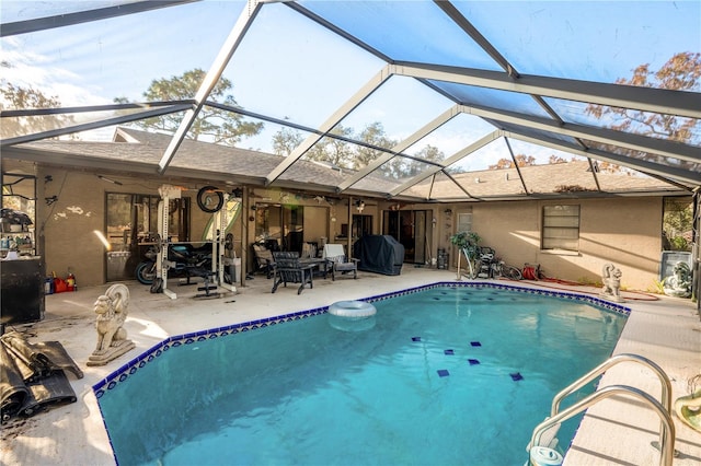 view of swimming pool featuring a patio, glass enclosure, and grilling area