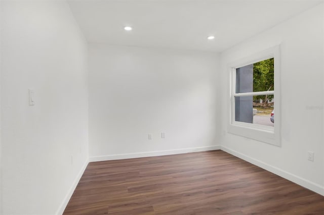 unfurnished room with dark wood-type flooring