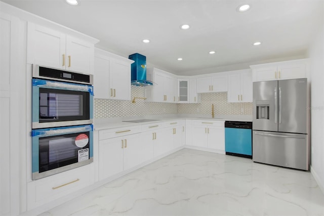 kitchen featuring sink, wall chimney range hood, backsplash, white cabinets, and appliances with stainless steel finishes