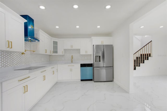 kitchen featuring light stone countertops, stainless steel appliances, wall chimney range hood, sink, and white cabinetry