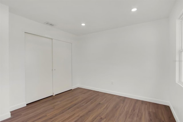 unfurnished bedroom with wood-type flooring and a closet