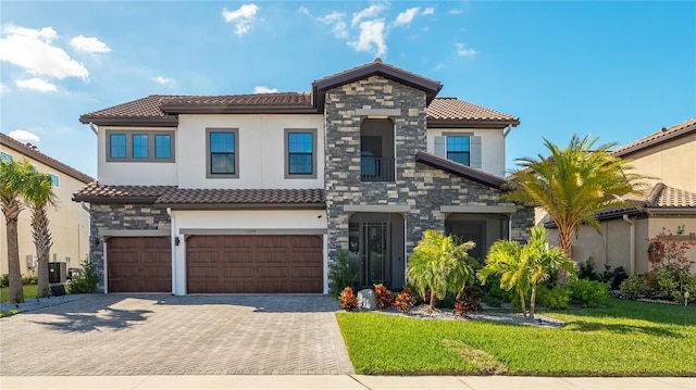 mediterranean / spanish-style home featuring cooling unit, a front yard, and a garage