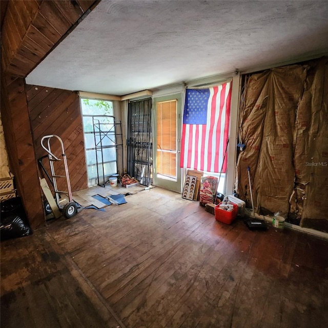 misc room with hardwood / wood-style floors and wooden walls