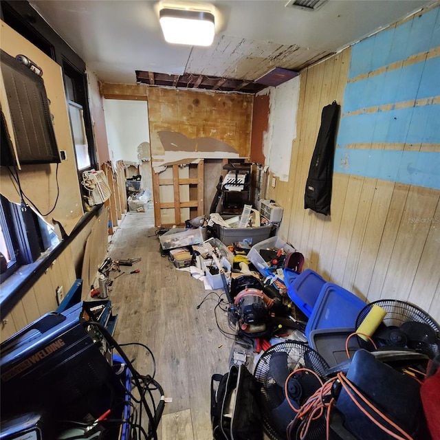 miscellaneous room with wooden walls and light hardwood / wood-style flooring