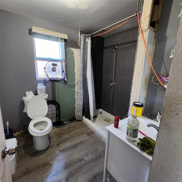 bathroom featuring a shower with shower curtain, toilet, and hardwood / wood-style flooring