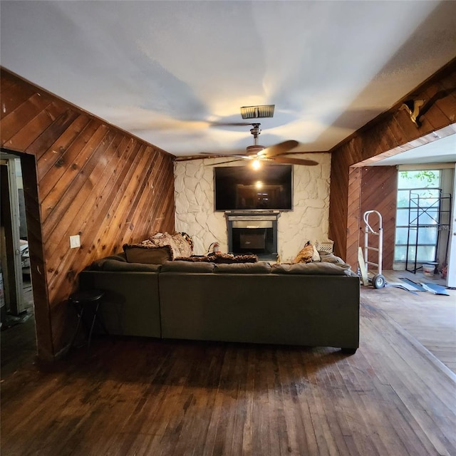 living room featuring hardwood / wood-style floors, a fireplace, and wooden walls