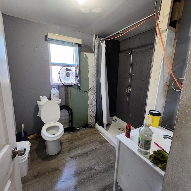 bathroom featuring hardwood / wood-style flooring, curtained shower, and toilet