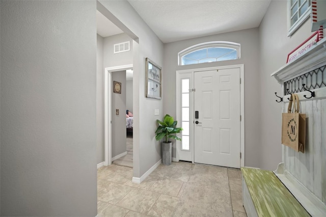 tiled foyer featuring a textured ceiling