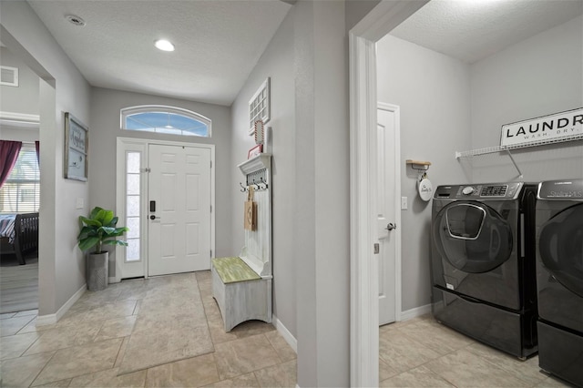 washroom featuring washer and dryer and a textured ceiling