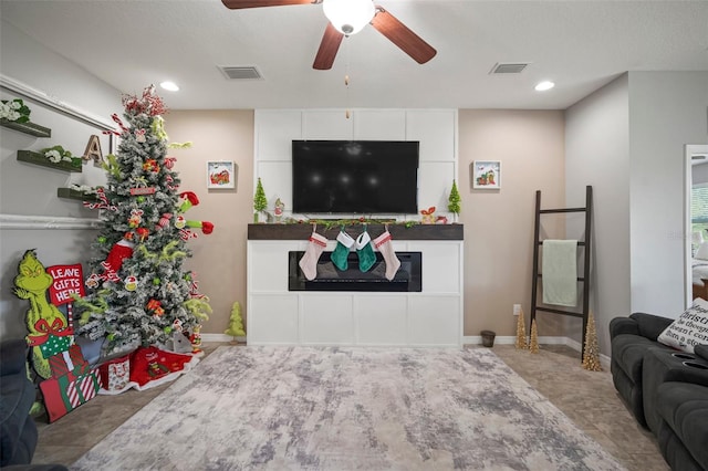 living room with ceiling fan and a textured ceiling