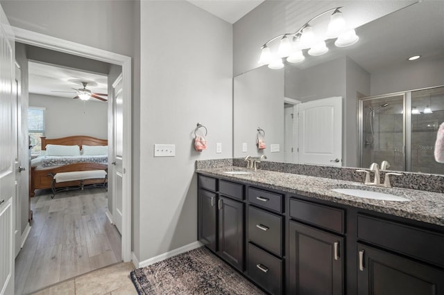 bathroom featuring wood-type flooring, vanity, a shower with door, and ceiling fan