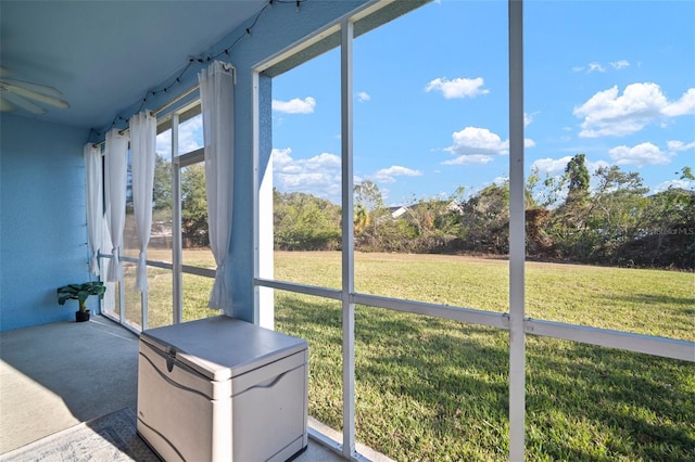 unfurnished sunroom featuring ceiling fan