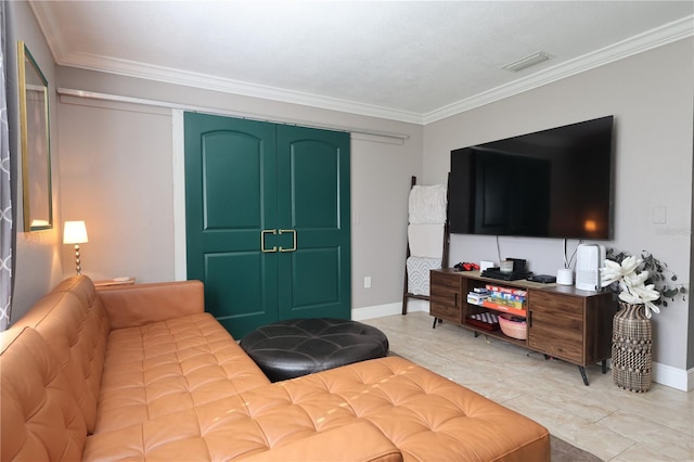 bedroom with tile patterned floors, crown molding, and a closet