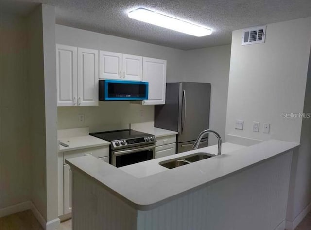 kitchen with white cabinetry, kitchen peninsula, sink, and appliances with stainless steel finishes