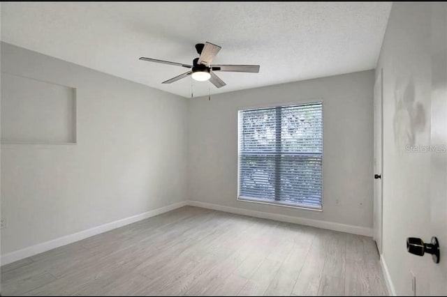 empty room featuring ceiling fan, a textured ceiling, and light wood-type flooring