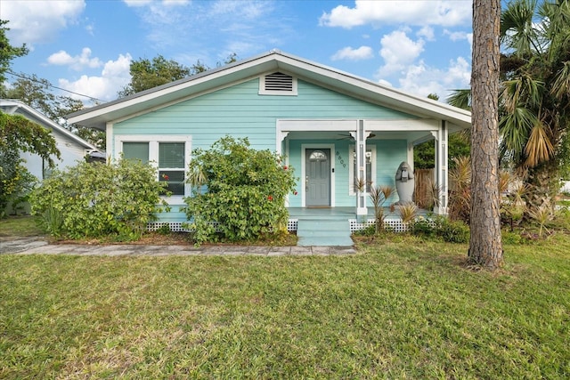 bungalow-style home featuring covered porch and a front yard