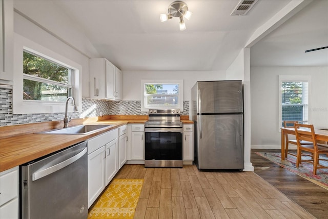 kitchen featuring white cabinets, stainless steel appliances, light hardwood / wood-style floors, and sink