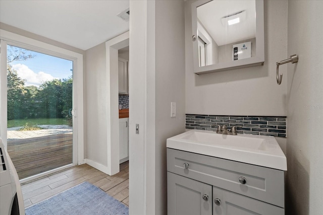 bathroom with vanity and tasteful backsplash