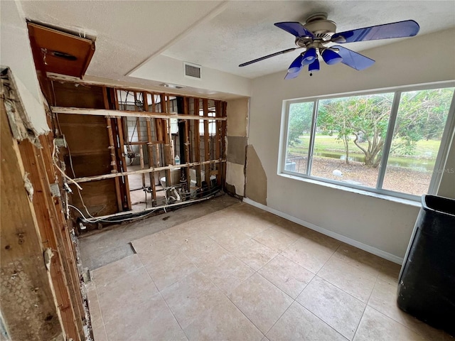 tiled spare room featuring ceiling fan and a textured ceiling