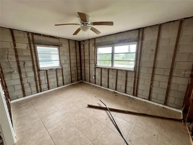 empty room with ceiling fan and a wealth of natural light